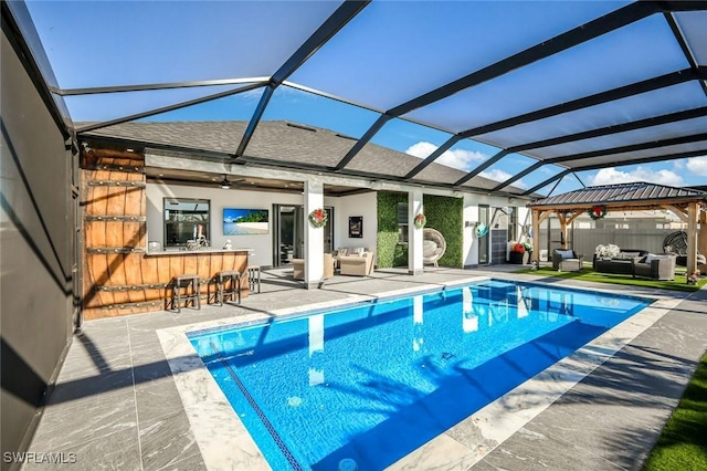 view of swimming pool featuring glass enclosure, outdoor dry bar, outdoor lounge area, and a patio area