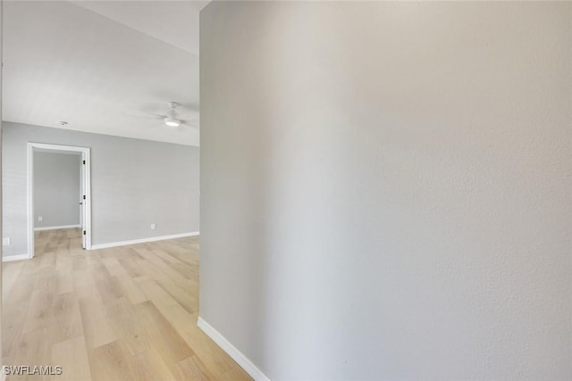 hall featuring baseboards and light wood-style flooring