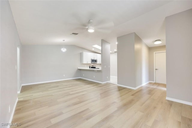 unfurnished living room featuring baseboards, visible vents, light wood-style flooring, ceiling fan, and vaulted ceiling