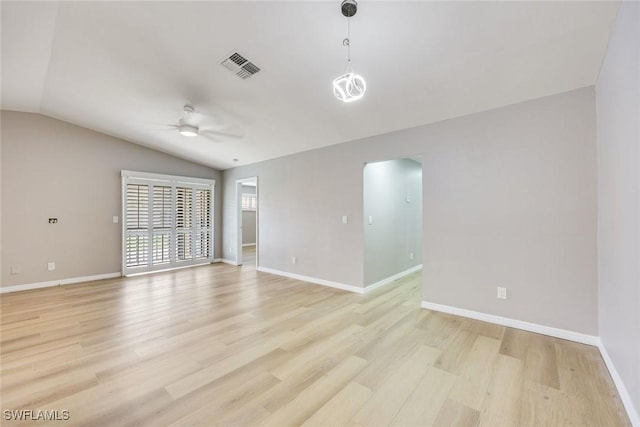 unfurnished room featuring baseboards, visible vents, ceiling fan, vaulted ceiling, and light wood-type flooring