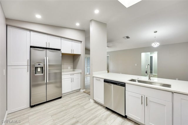 kitchen featuring visible vents, a sink, light countertops, white cabinets, and appliances with stainless steel finishes