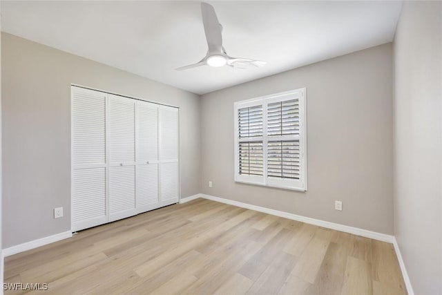 unfurnished bedroom featuring a closet, baseboards, and light wood finished floors