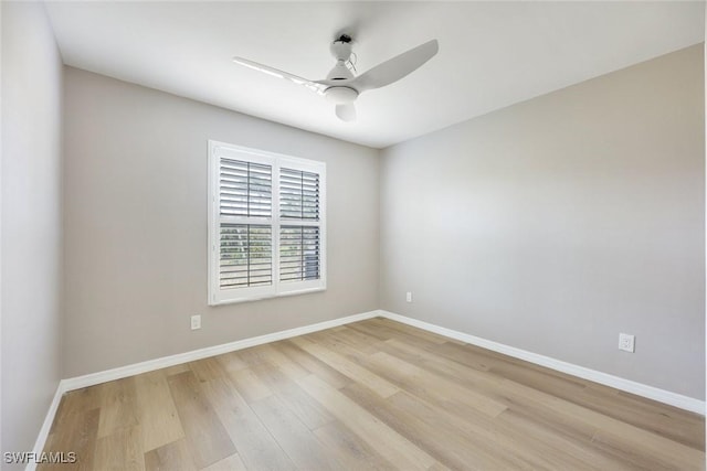 empty room featuring a ceiling fan, light wood-style floors, and baseboards