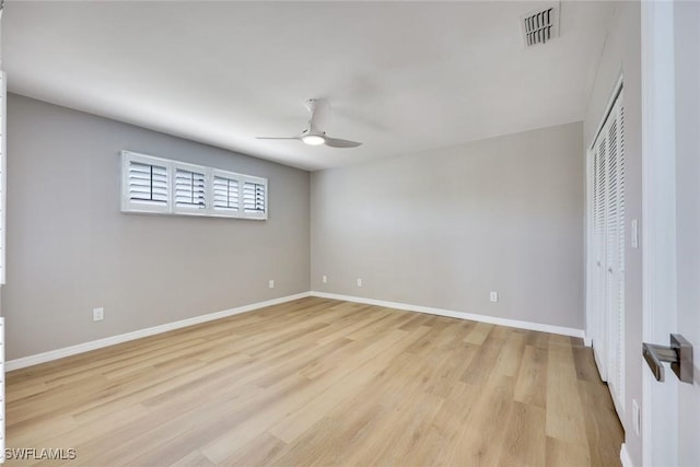 unfurnished bedroom featuring visible vents, a ceiling fan, a closet, light wood finished floors, and baseboards