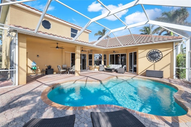 rear view of property featuring a tile roof, stucco siding, an outdoor hangout area, a patio area, and an outdoor pool