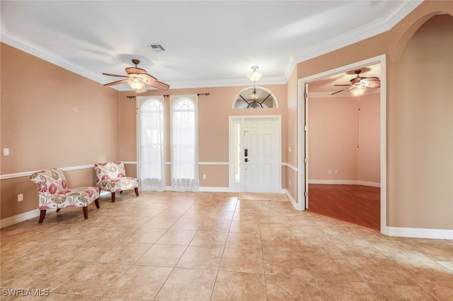 entrance foyer featuring baseboards, arched walkways, light tile patterned flooring, and crown molding