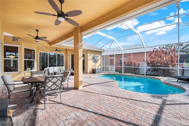 pool featuring glass enclosure, a ceiling fan, and a patio area