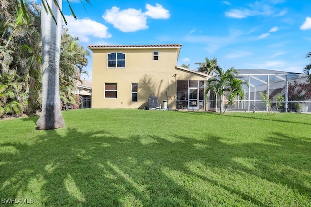 rear view of house featuring a tiled roof, central AC unit, a lawn, stucco siding, and a sunroom