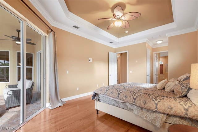 bedroom featuring visible vents, light wood-style flooring, baseboards, and a tray ceiling