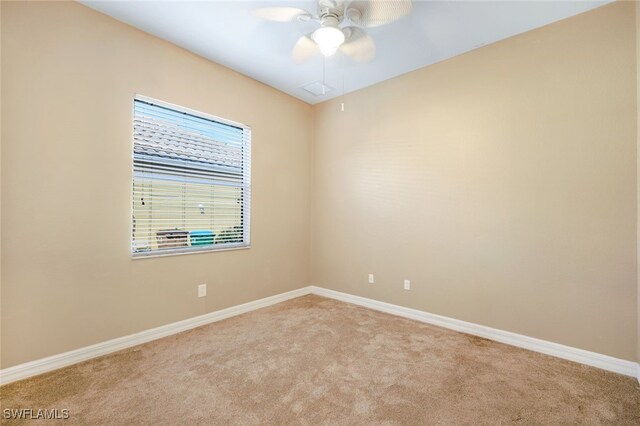 carpeted empty room featuring baseboards and ceiling fan