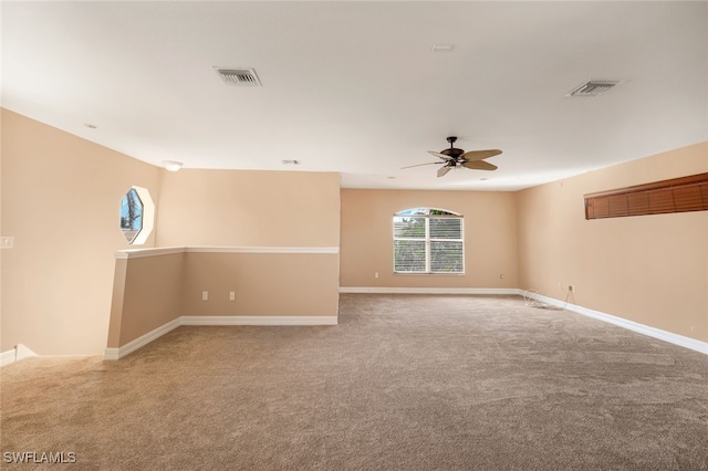 unfurnished room with visible vents, light carpet, and baseboards