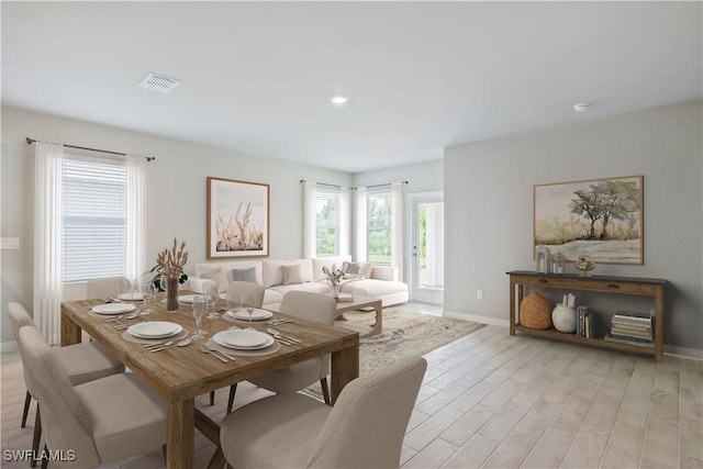 dining room featuring visible vents, light wood-style flooring, and baseboards