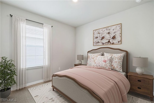 bedroom with baseboards and light carpet