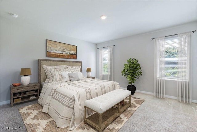 carpeted bedroom featuring multiple windows and baseboards