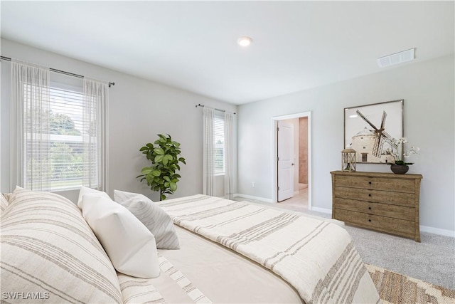 bedroom with visible vents, light carpet, and baseboards