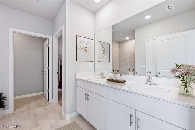 full bathroom featuring double vanity, visible vents, baseboards, and a sink