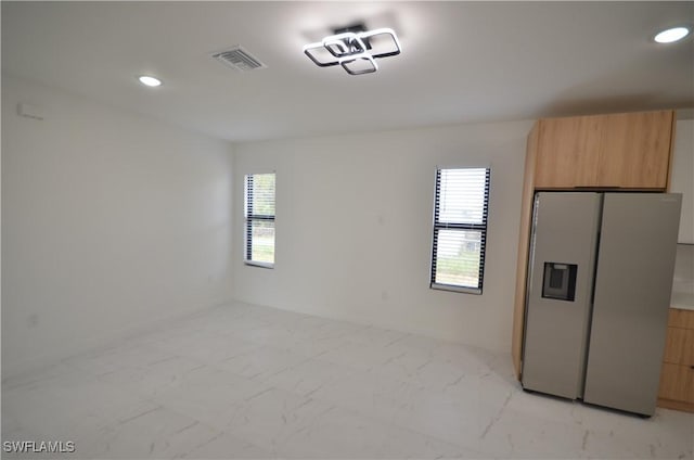 interior space featuring visible vents, modern cabinets, marble finish floor, recessed lighting, and stainless steel fridge