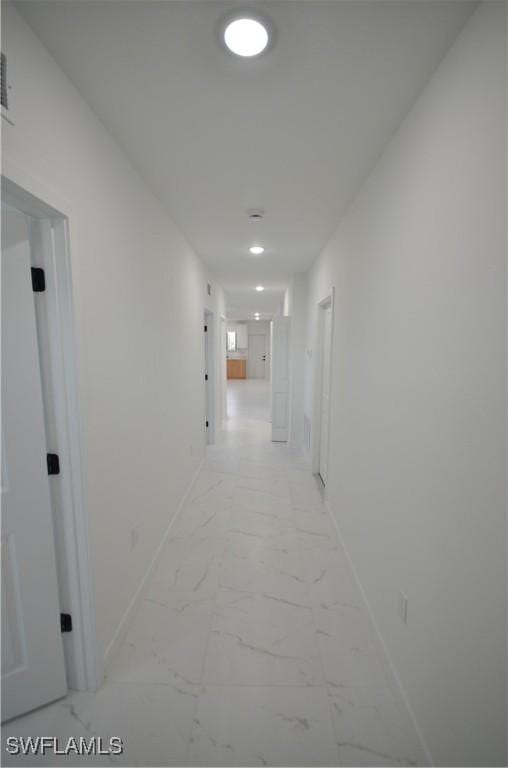 hall with baseboards and marble finish floor