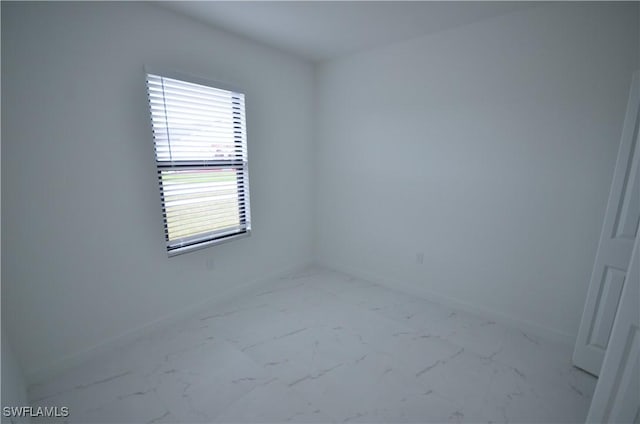 empty room featuring baseboards and marble finish floor