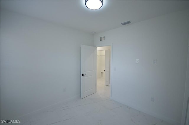 empty room with visible vents, marble finish floor, and baseboards