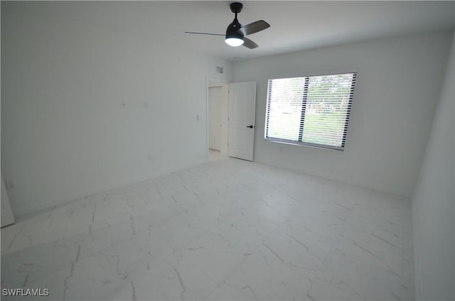 unfurnished room featuring visible vents, marble finish floor, and ceiling fan