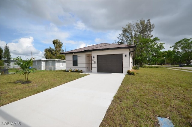 view of front facade with a front yard, driveway, a standing seam roof, an attached garage, and metal roof