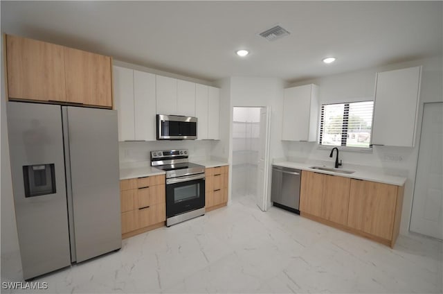 kitchen with visible vents, marble finish floor, a sink, appliances with stainless steel finishes, and light countertops