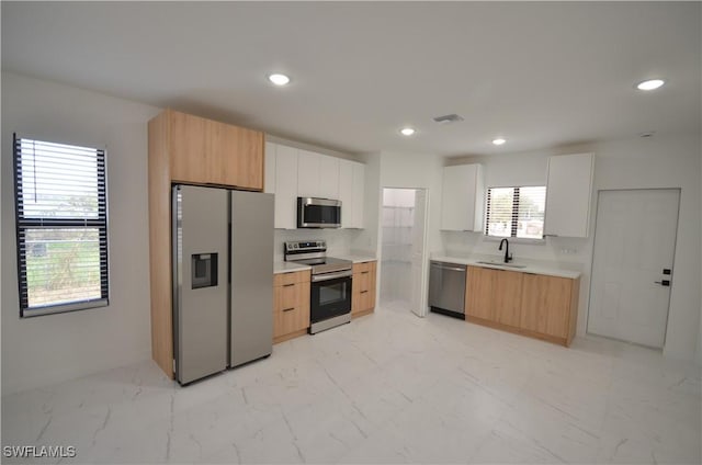 kitchen featuring visible vents, a sink, light countertops, appliances with stainless steel finishes, and marble finish floor