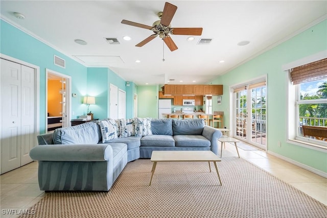 living area with crown molding, light tile patterned flooring, and visible vents