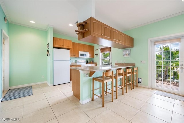 kitchen with light tile patterned floors, white appliances, and ornamental molding