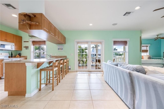 kitchen featuring visible vents, white appliances, light countertops, and open floor plan