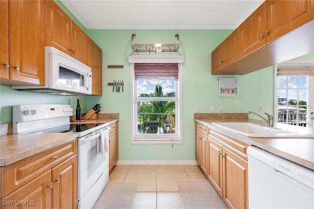 kitchen featuring a wealth of natural light, white appliances, light countertops, and a sink