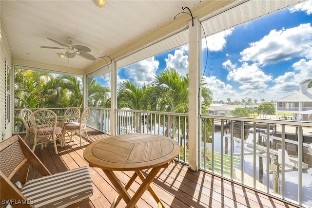 sunroom / solarium with a water view and ceiling fan