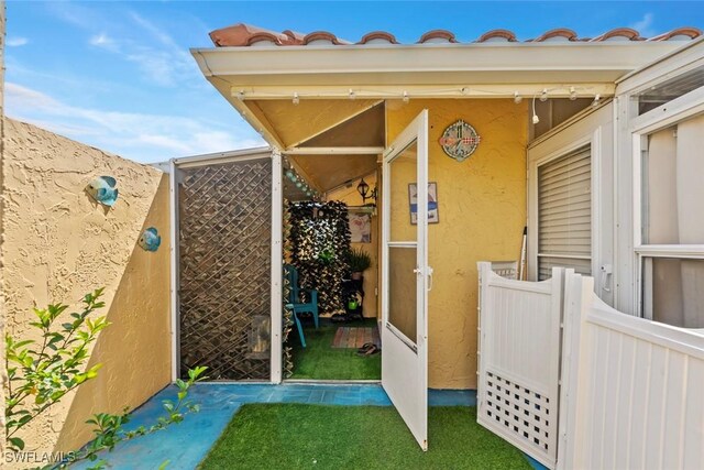 exterior space featuring stucco siding and fence