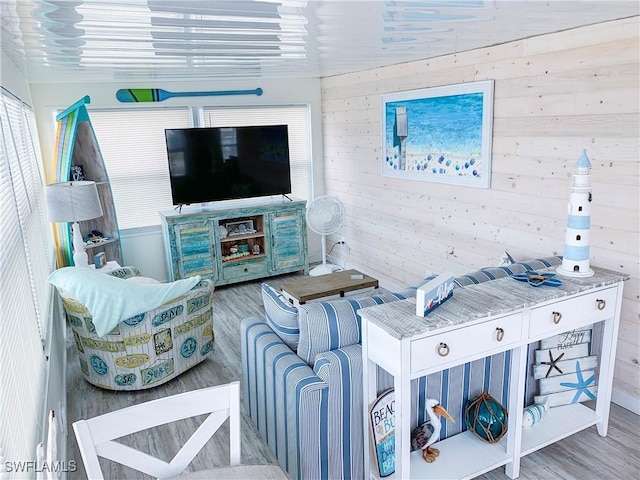 living area featuring wooden walls and wood finished floors