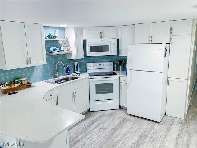 kitchen with light wood-style flooring, white appliances, open shelves, and a sink