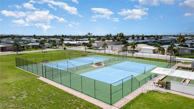 view of sport court with a residential view, a lawn, and fence