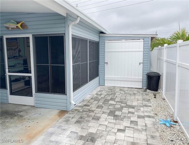 view of patio featuring a fenced backyard and a sunroom