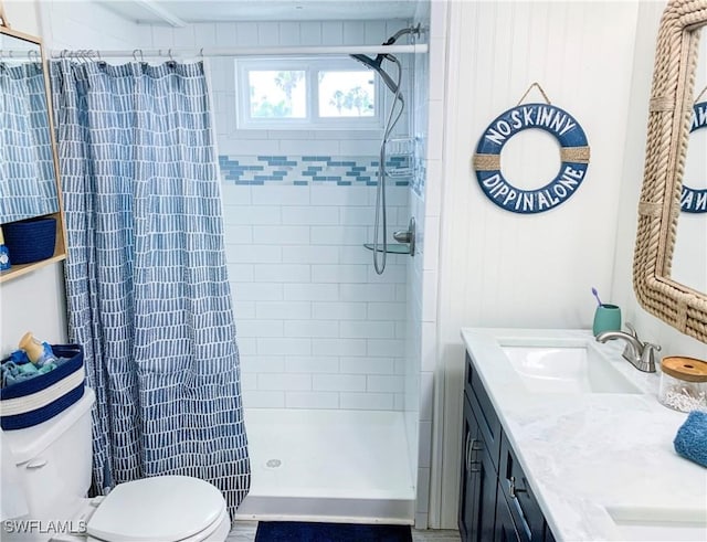 bathroom with toilet, a shower stall, and vanity