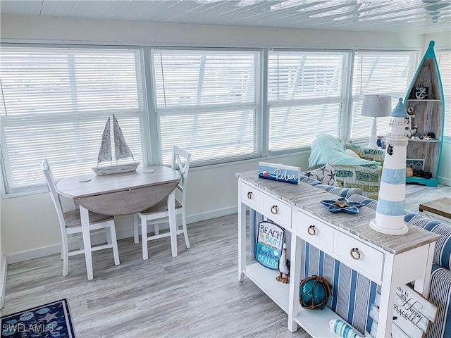 dining room with a wealth of natural light, baseboards, and light wood finished floors