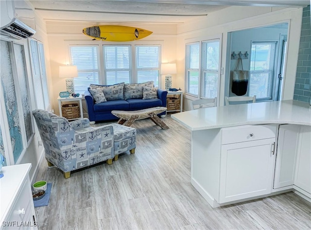 living room with beam ceiling, an AC wall unit, and light wood-type flooring