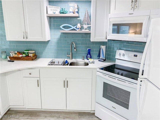 kitchen with white appliances, white cabinets, open shelves, and a sink