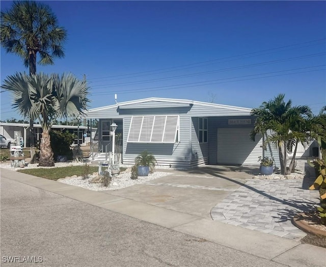 manufactured / mobile home with a carport and concrete driveway