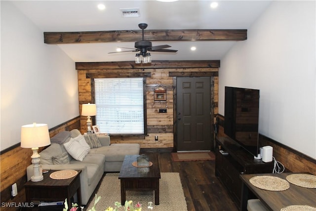 living area featuring visible vents, beam ceiling, wooden walls, and dark wood-type flooring