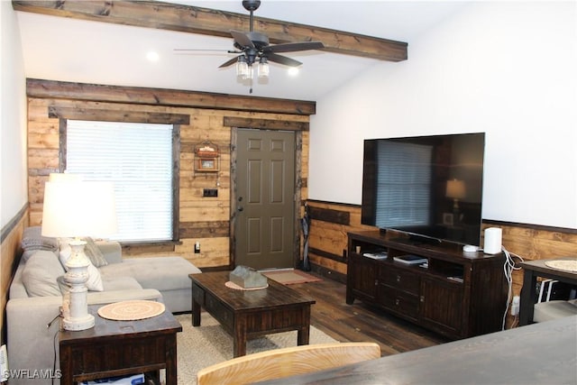 living area featuring wooden walls, beamed ceiling, and a wainscoted wall