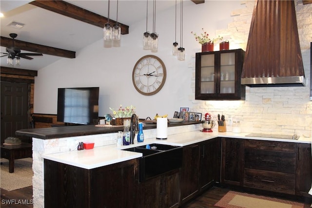 kitchen featuring premium range hood, a peninsula, light countertops, glass insert cabinets, and black electric stovetop