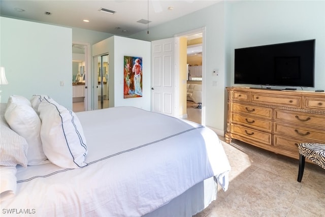 bedroom with light tile patterned floors, visible vents, and ensuite bathroom