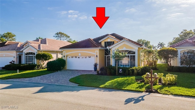 view of front of house with stucco siding, an attached garage, decorative driveway, and a front yard