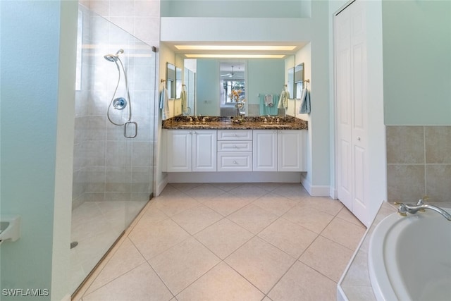 full bath with a stall shower, a closet, tile patterned flooring, double vanity, and a bath