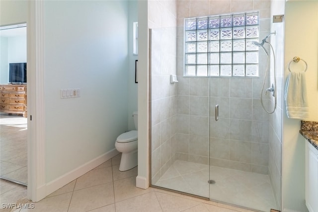 bathroom with tile patterned floors, toilet, a shower stall, baseboards, and vanity